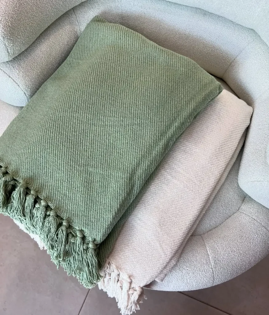 Two throw blankets on a sofa